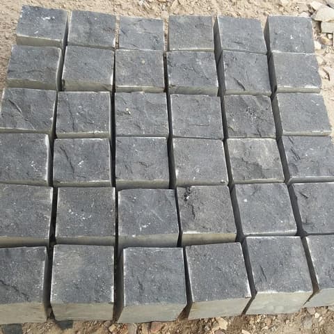 Black basalt paving cubes stacked on a pallet