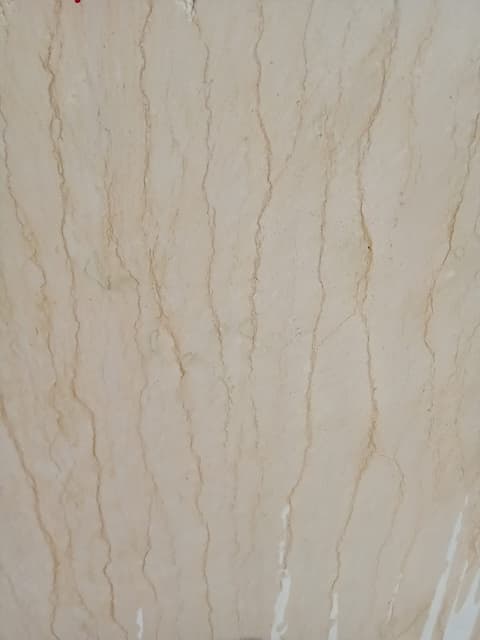 Close-up of a cut Minya marble block face with warm beige tone and golden veining