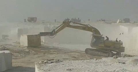 Excavator working marble blocks at the Minya quarry